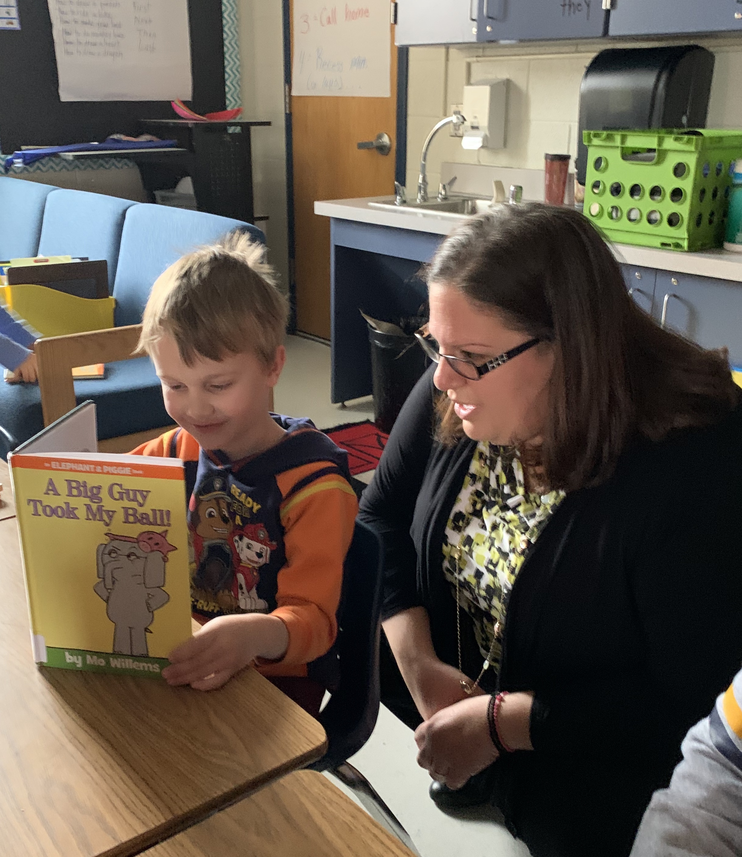 picture of school board member with student reading